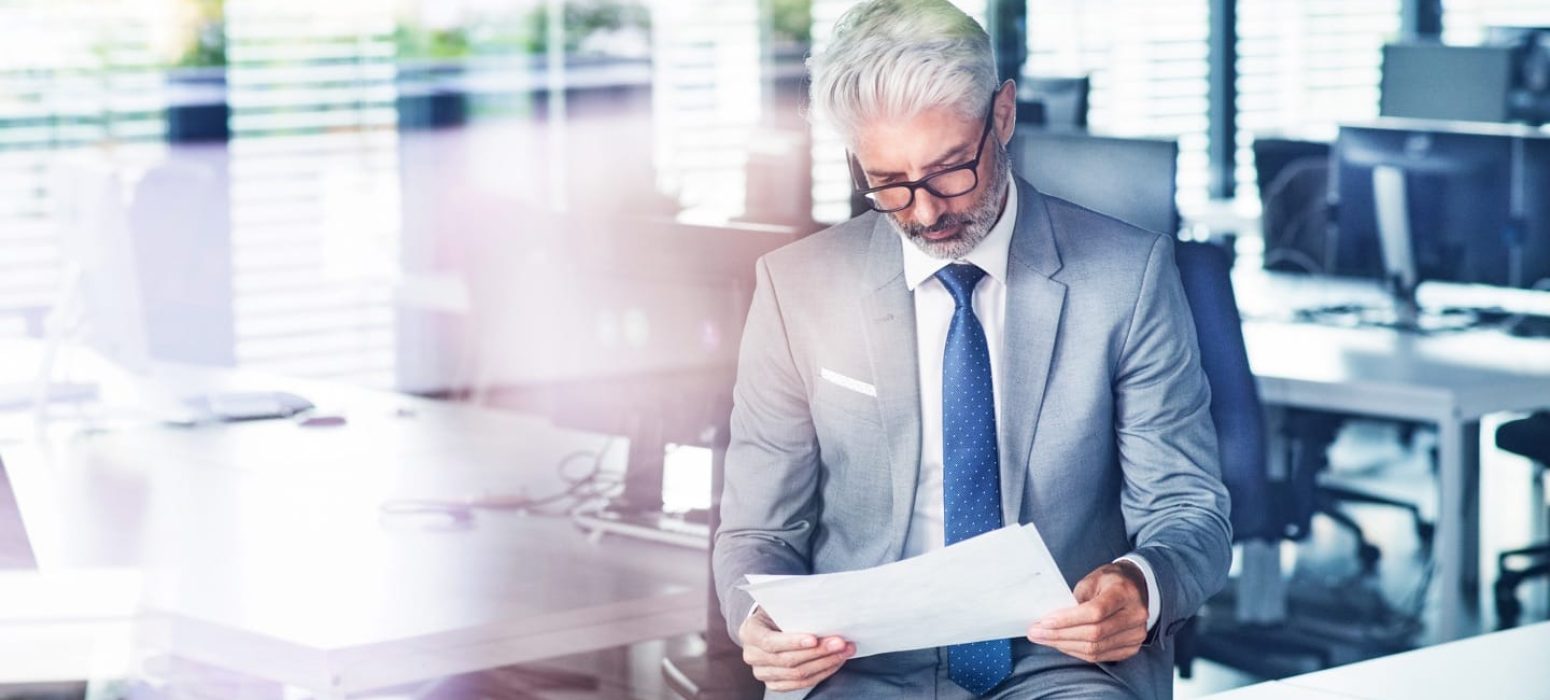mature-businessman-in-gray-suit-in-the-office-PTZQXAR